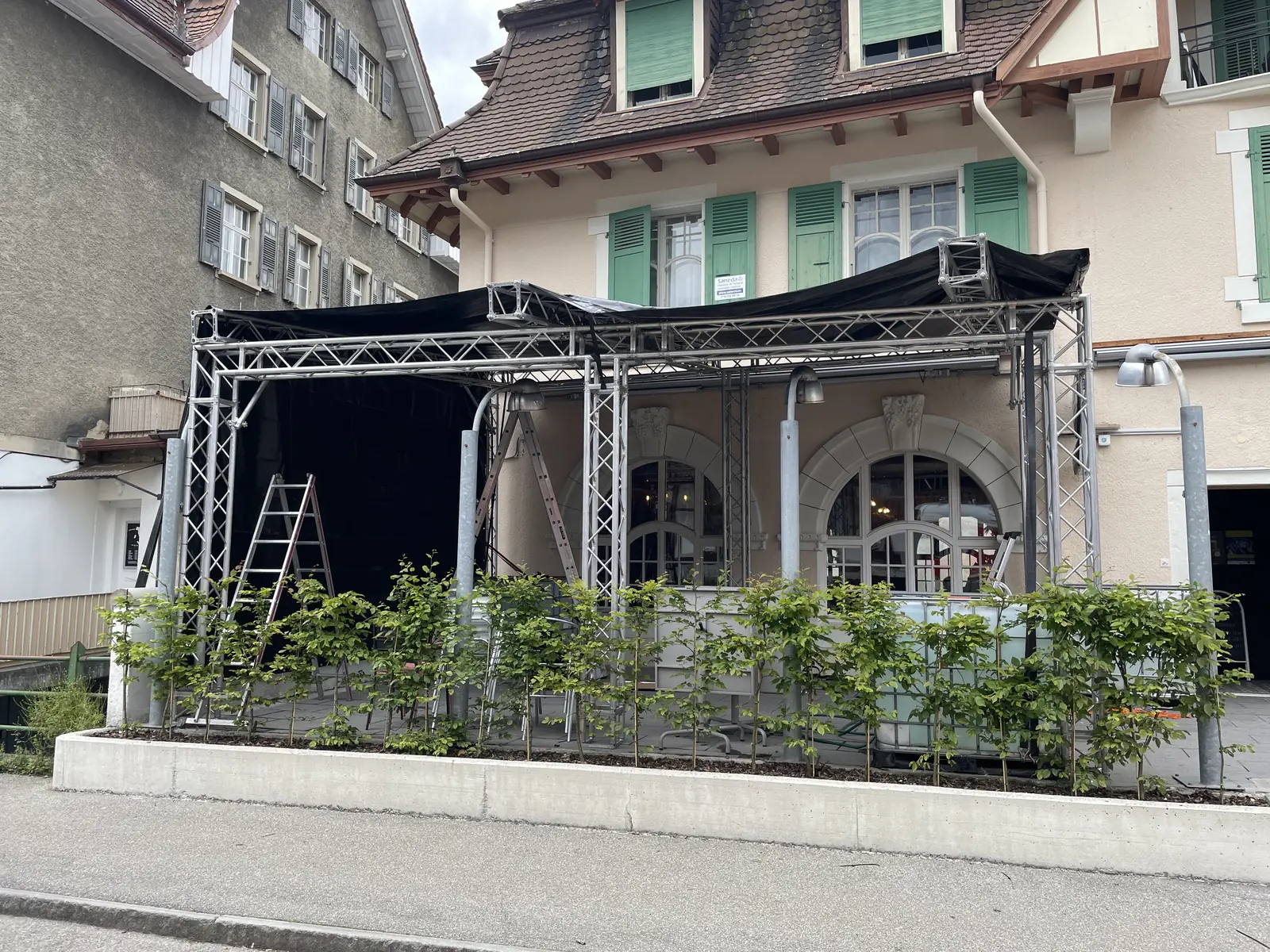 Couvert en structure truss bâché de noir monté sur la terrasse du Deli Bar, vu depuis la rue, pour la fan zone de l'Euro 2024